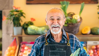 Elderly worker sells fruits. 