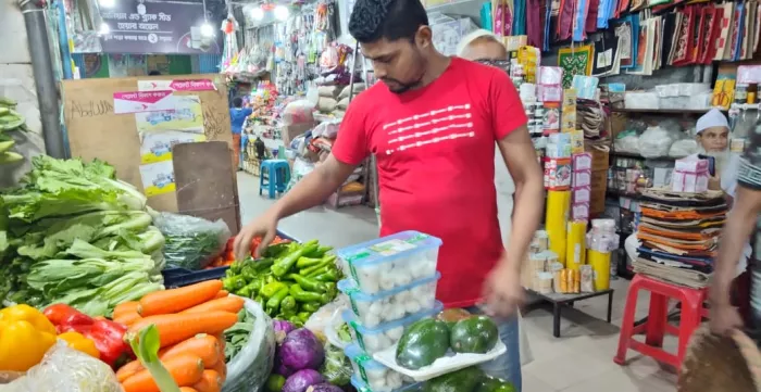 A trader at a market in Dhaka, Bangladesh arranges vegetables