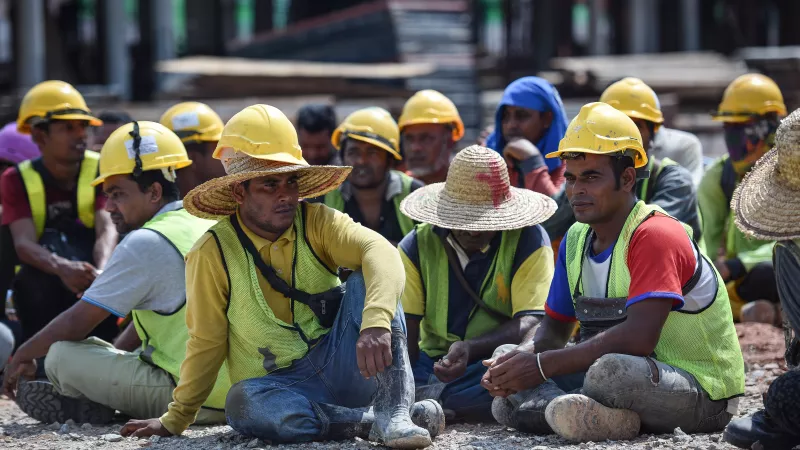 A group of migrant workers sit in the street in Malaysia