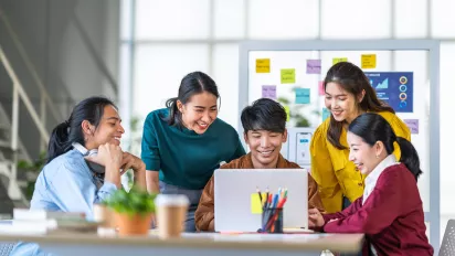 Young Asian women and men work together in a start up office