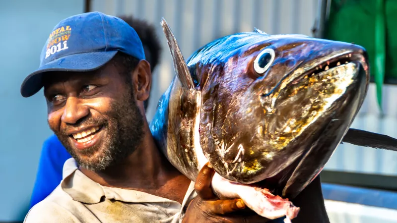 Fisherman carries a huge fish, Vanuatu.